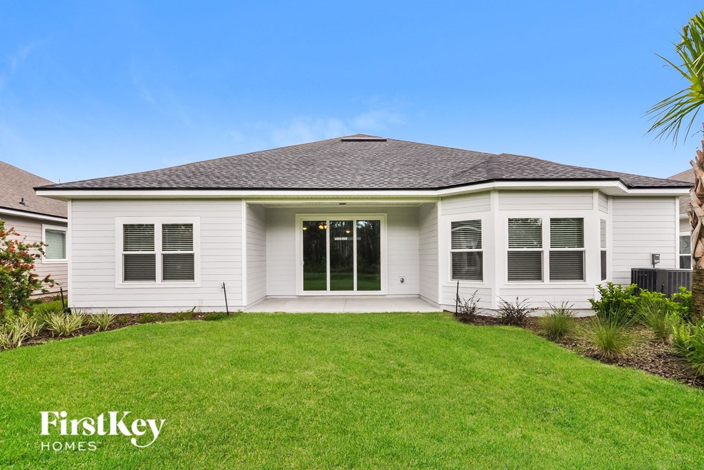 a white bungalow with a lawn and a porch