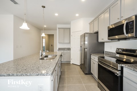 A kitchen with granite countertops and stainless steel appliances.