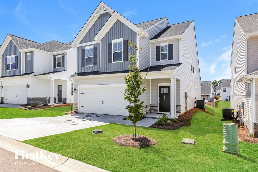 A row of houses with a tree in the front yard.