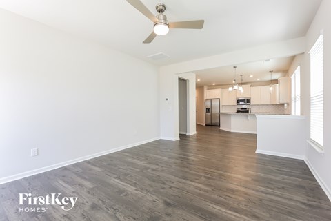 A spacious room with a ceiling fan and wooden flooring.