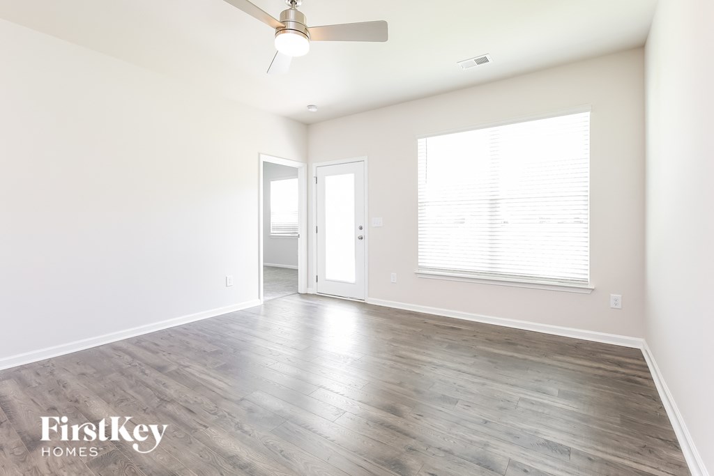 an empty living room with white walls and wood floors