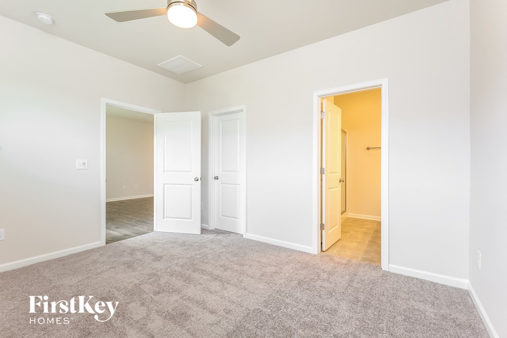 a living room with white walls and a ceiling fan