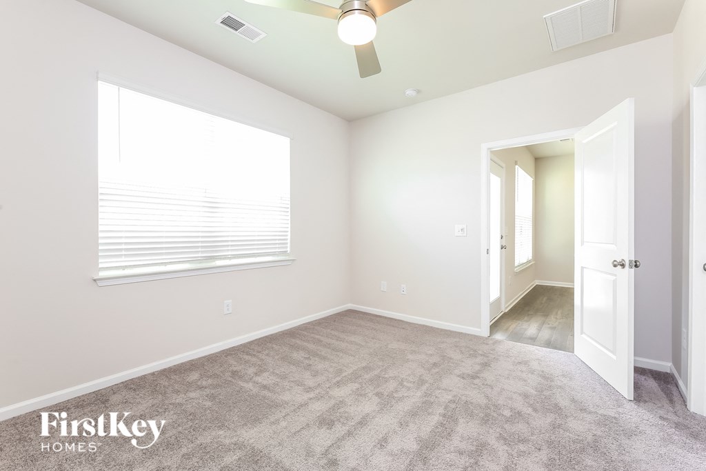 a bedroom with a carpeted floor and a large window
