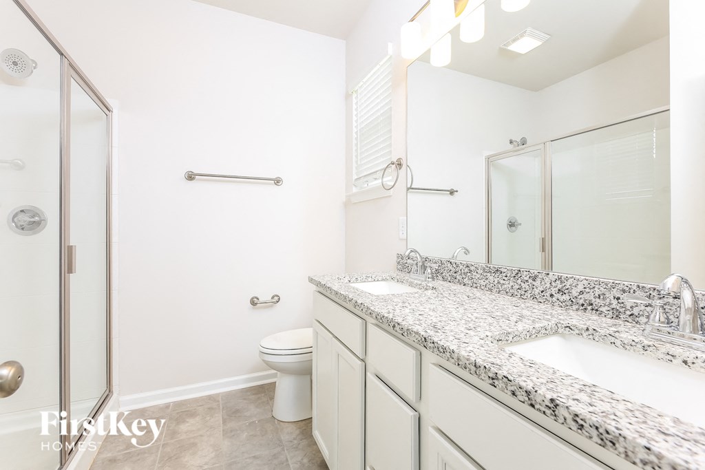 a bathroom with two sinks and a shower and a toilet