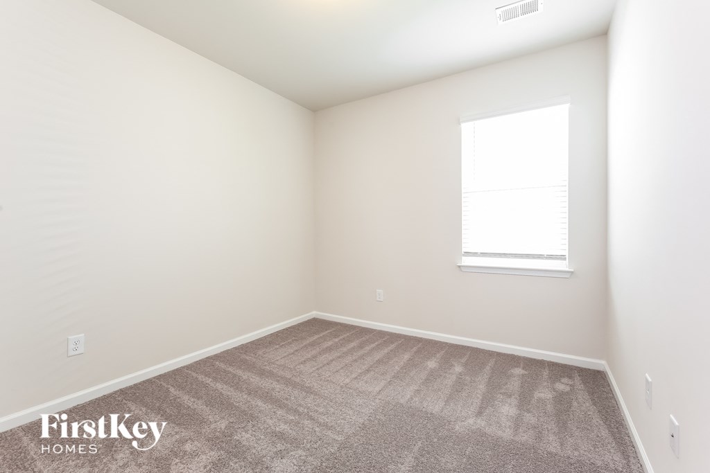 a bedroom with a carpeted floor and a window