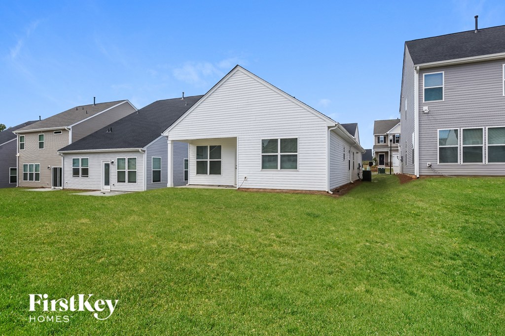 the backyard of a home with a green lawn and several houses