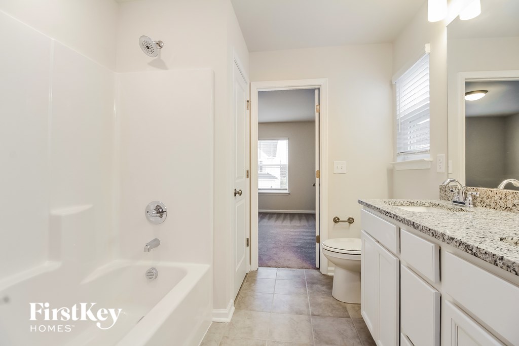 A white bathroom with a tub, toilet, and sink.