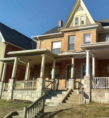 a large brick house with stairs and a porch