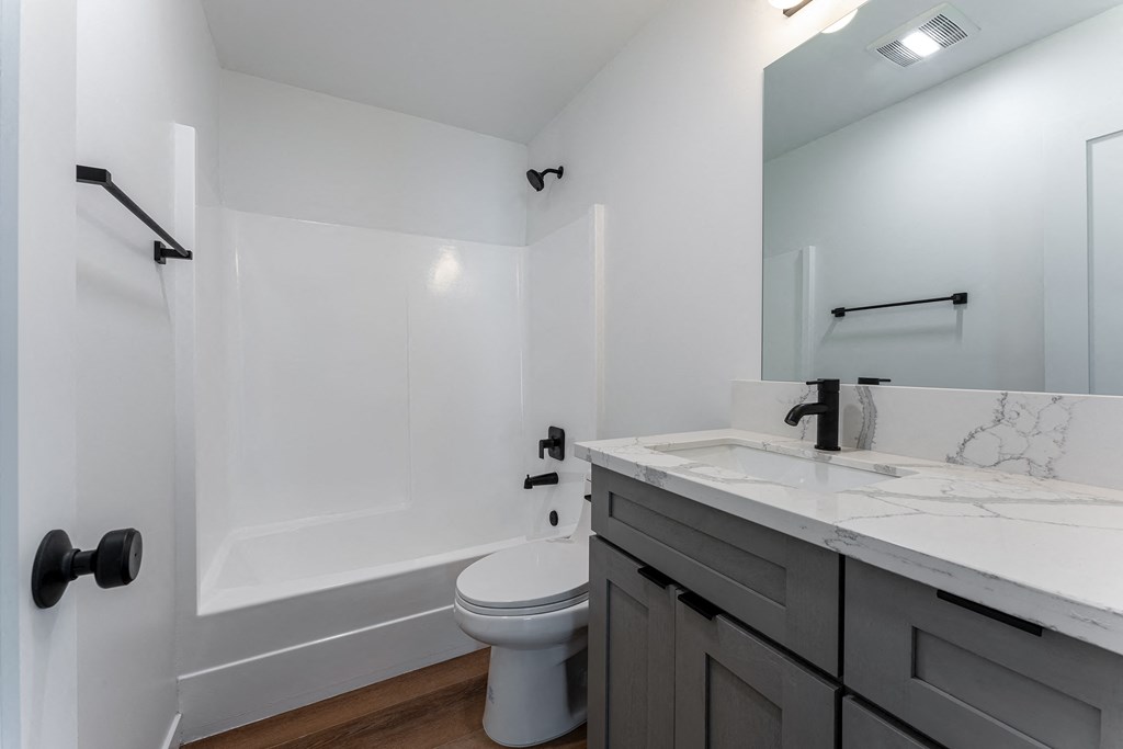 a bathroom with a toilet and a sink and a shower