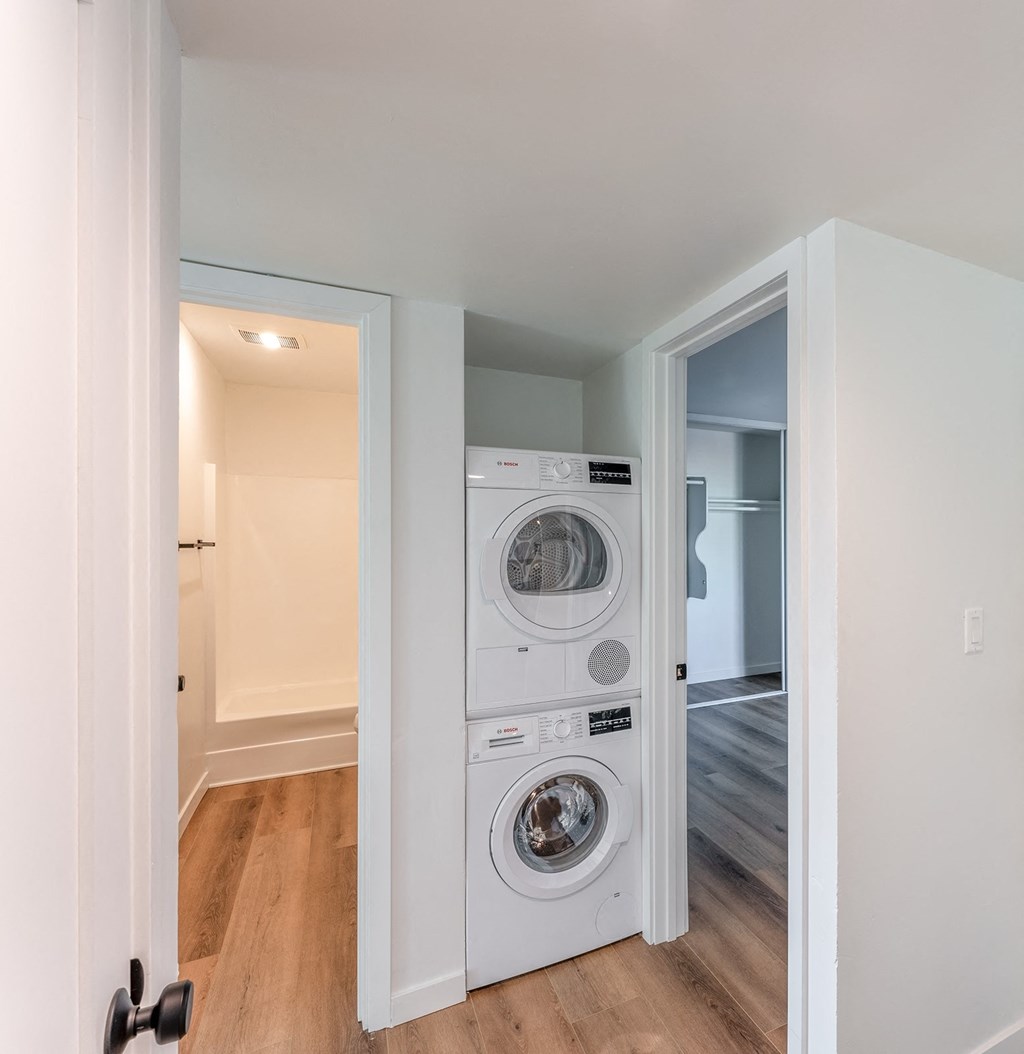 a small laundry room with a washer and dryer on the wall