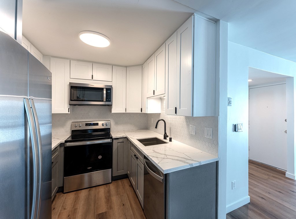 a kitchen with white cabinets and stainless steel appliances