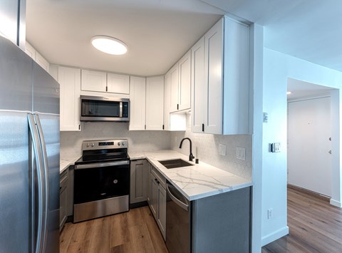a kitchen with white cabinets and stainless steel appliances