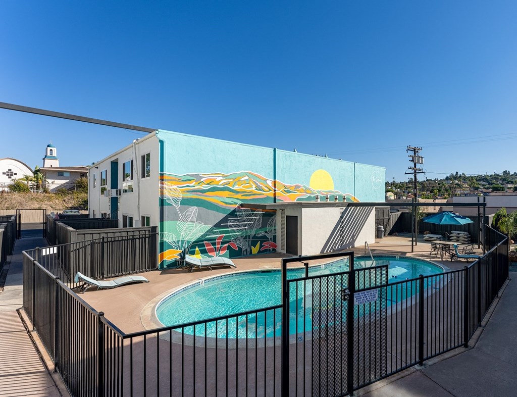a swimming pool with a mural on the side of a building