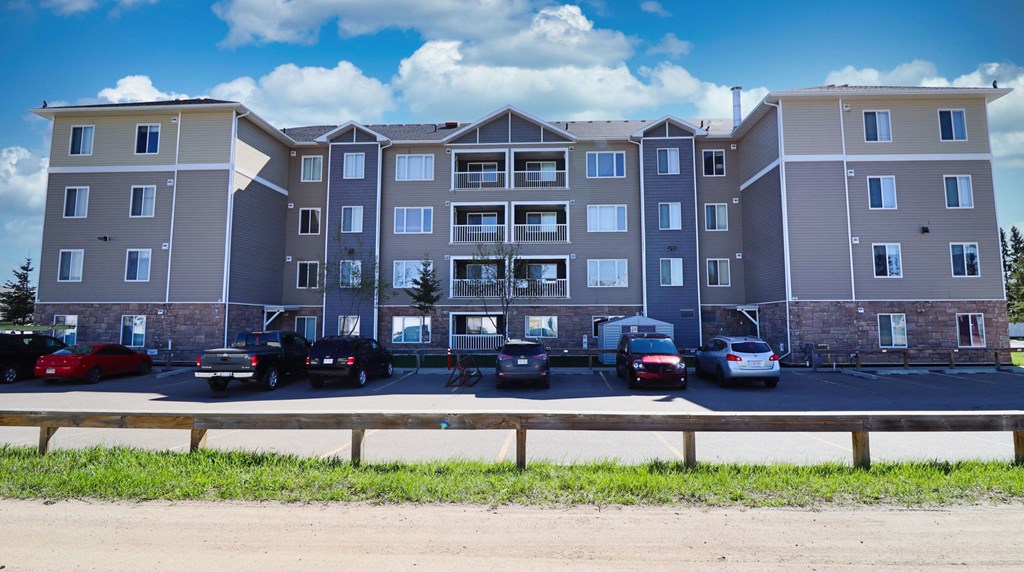 a large apartment building with cars parked in a parking lot