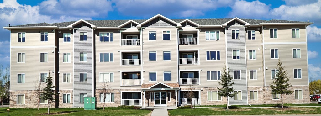 a large apartment building with a sidewalk in front of it