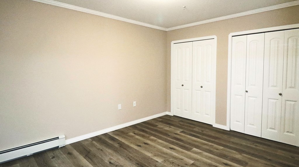 a room with wood floors and white closets