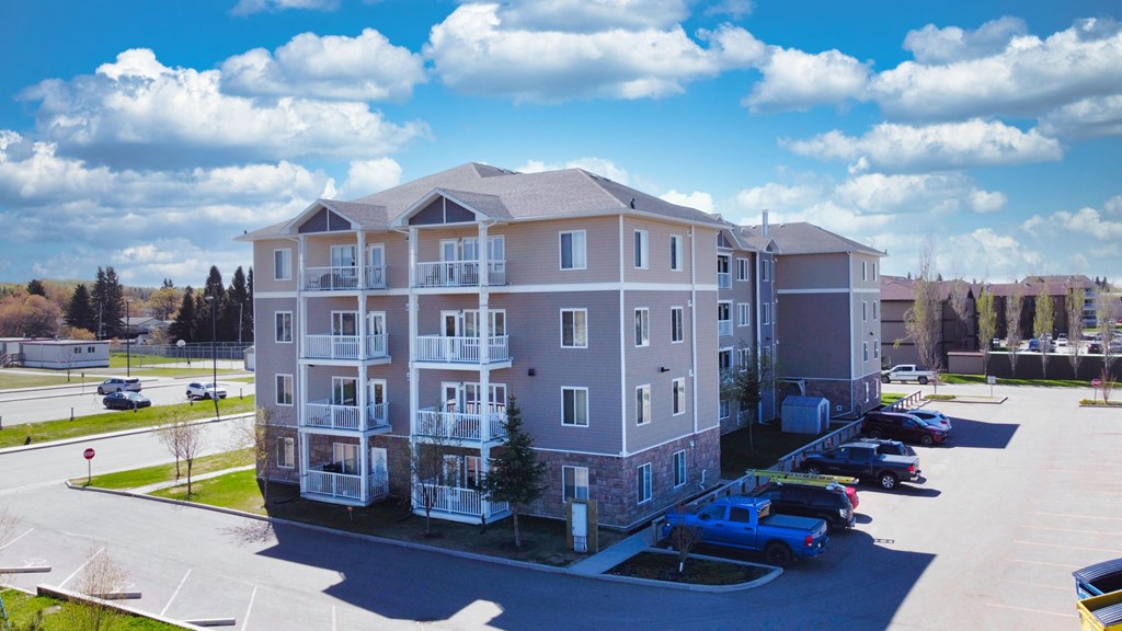an aerial view of an apartment building in a parking lot