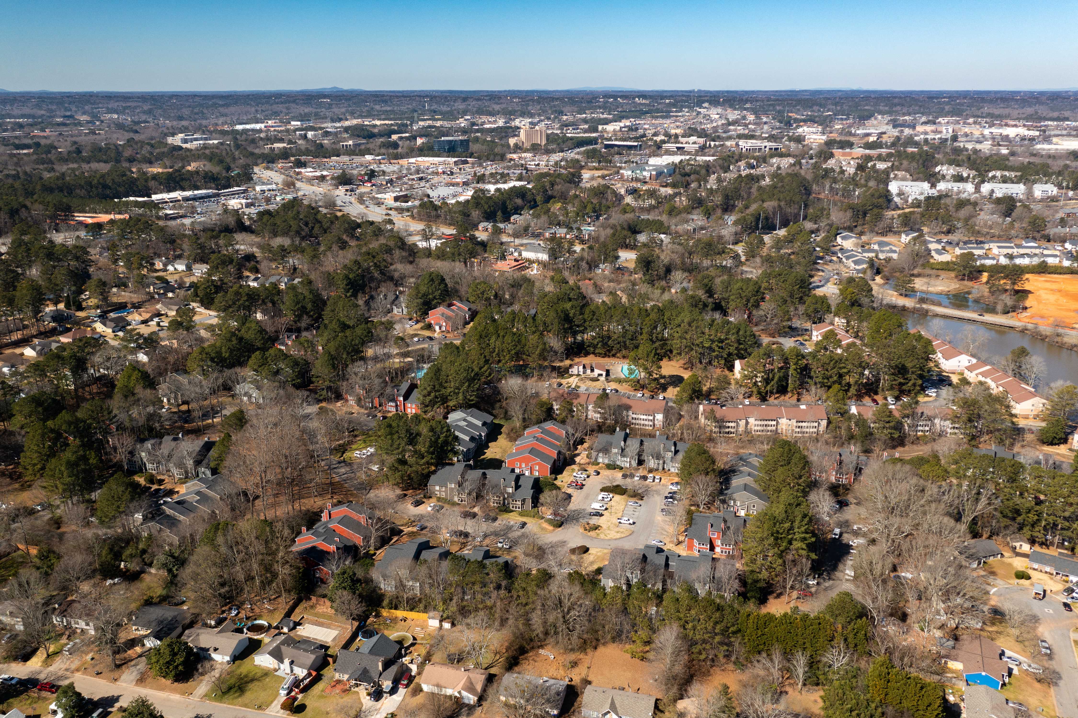 an aerial view of a neighborhood with houses and trees and a river