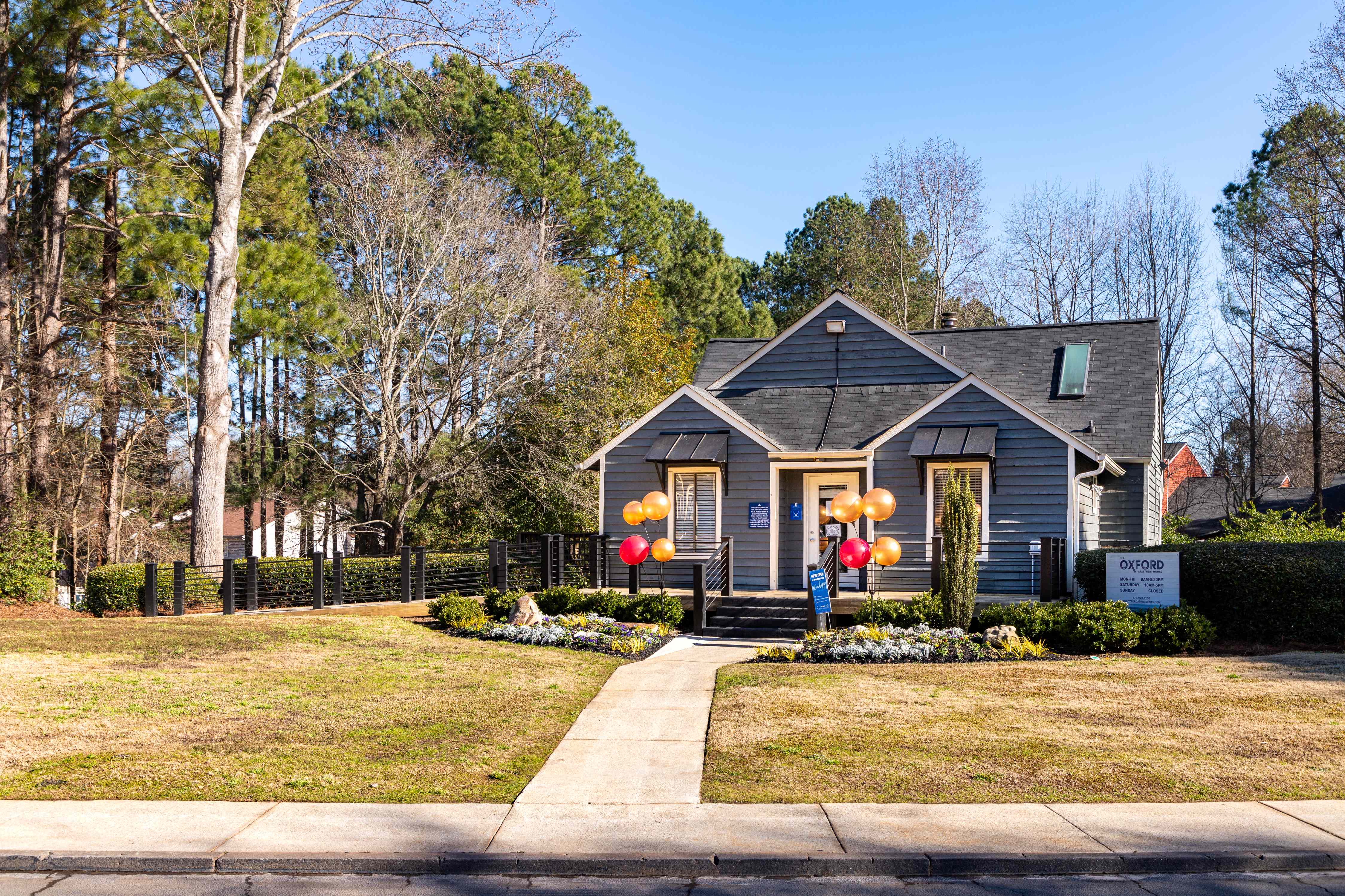 the front of a house with balloons on the lawn