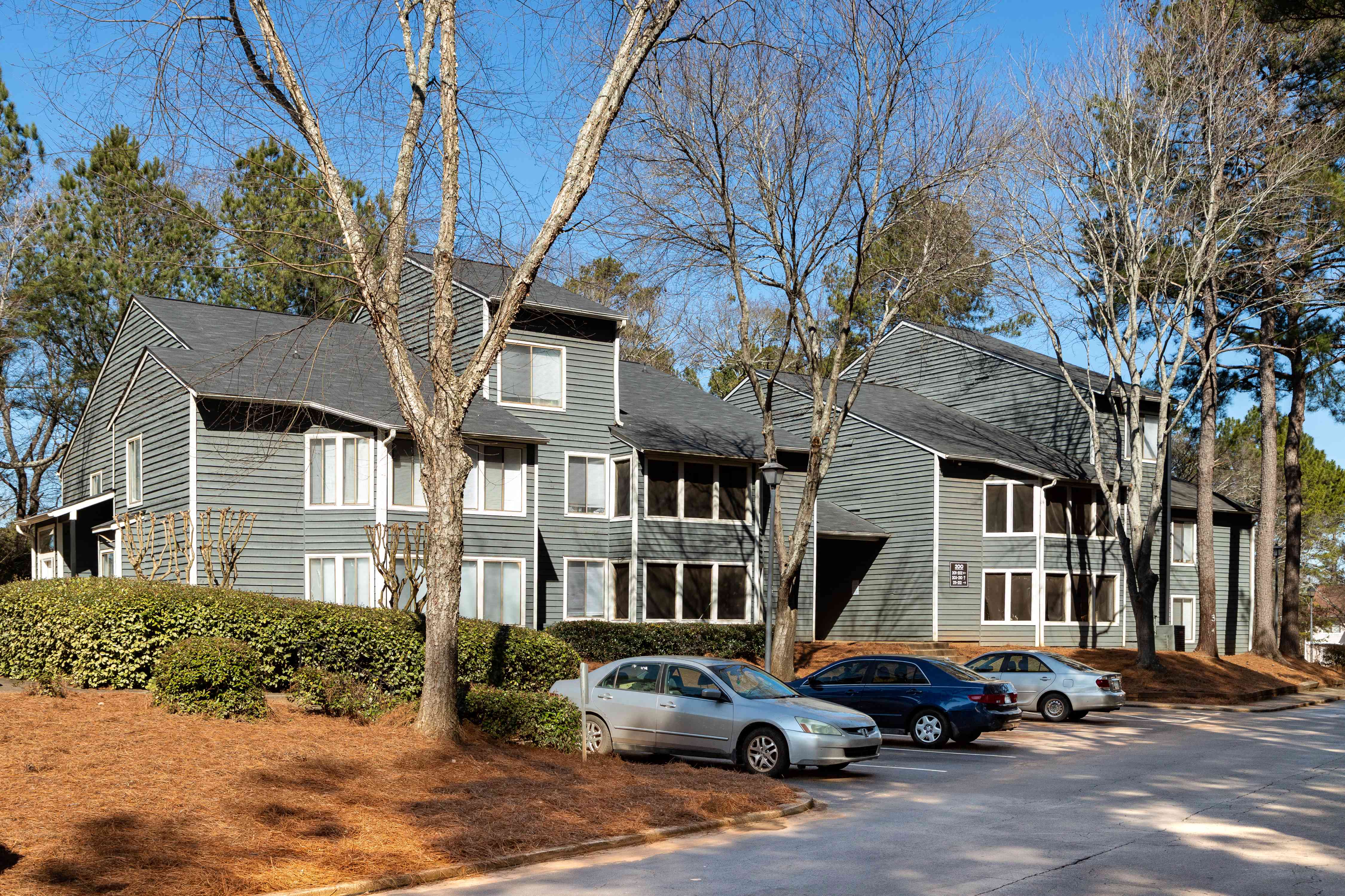 an apartment building with cars parked in front of it