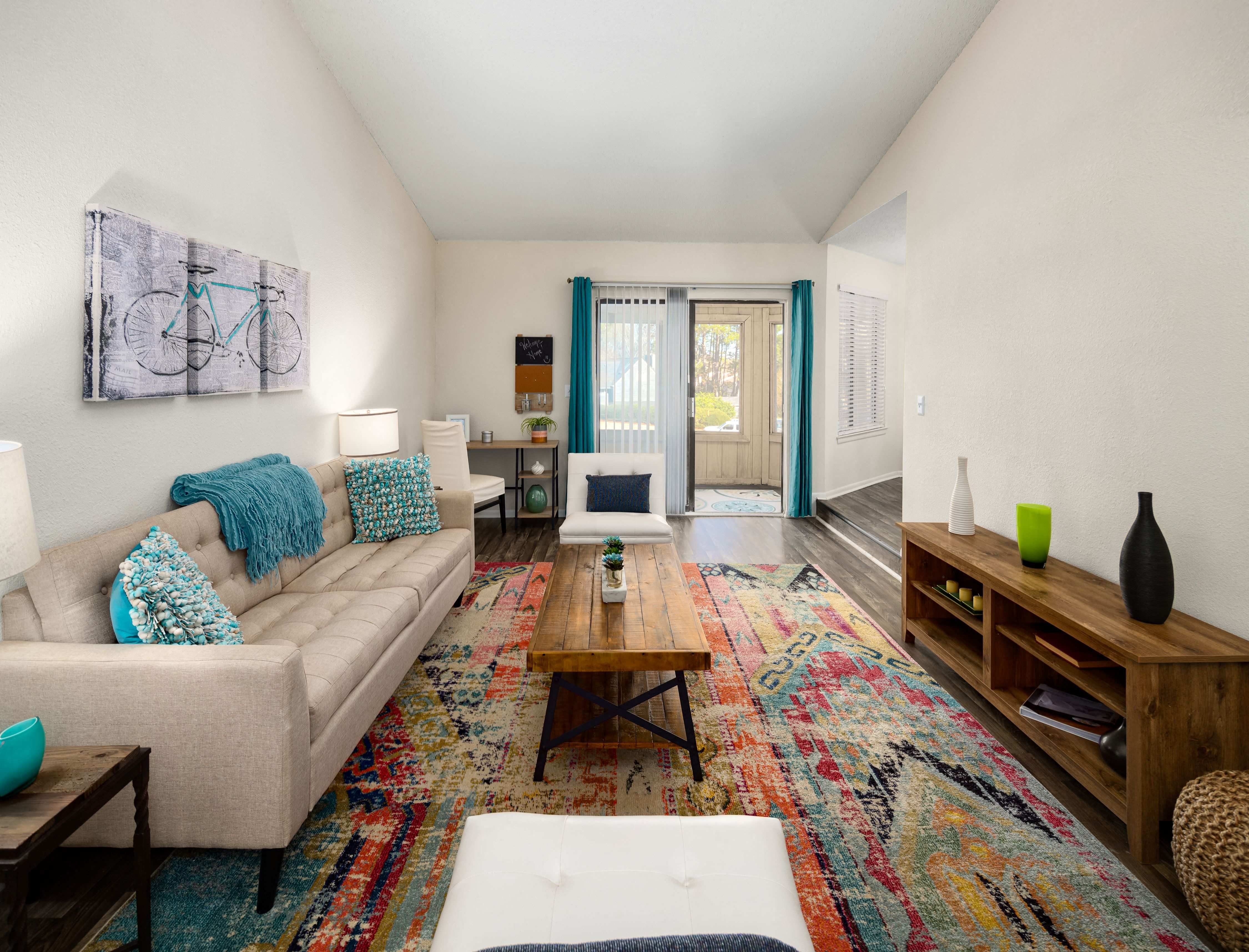 a living room with a couch and a coffee table and a door to a balcony