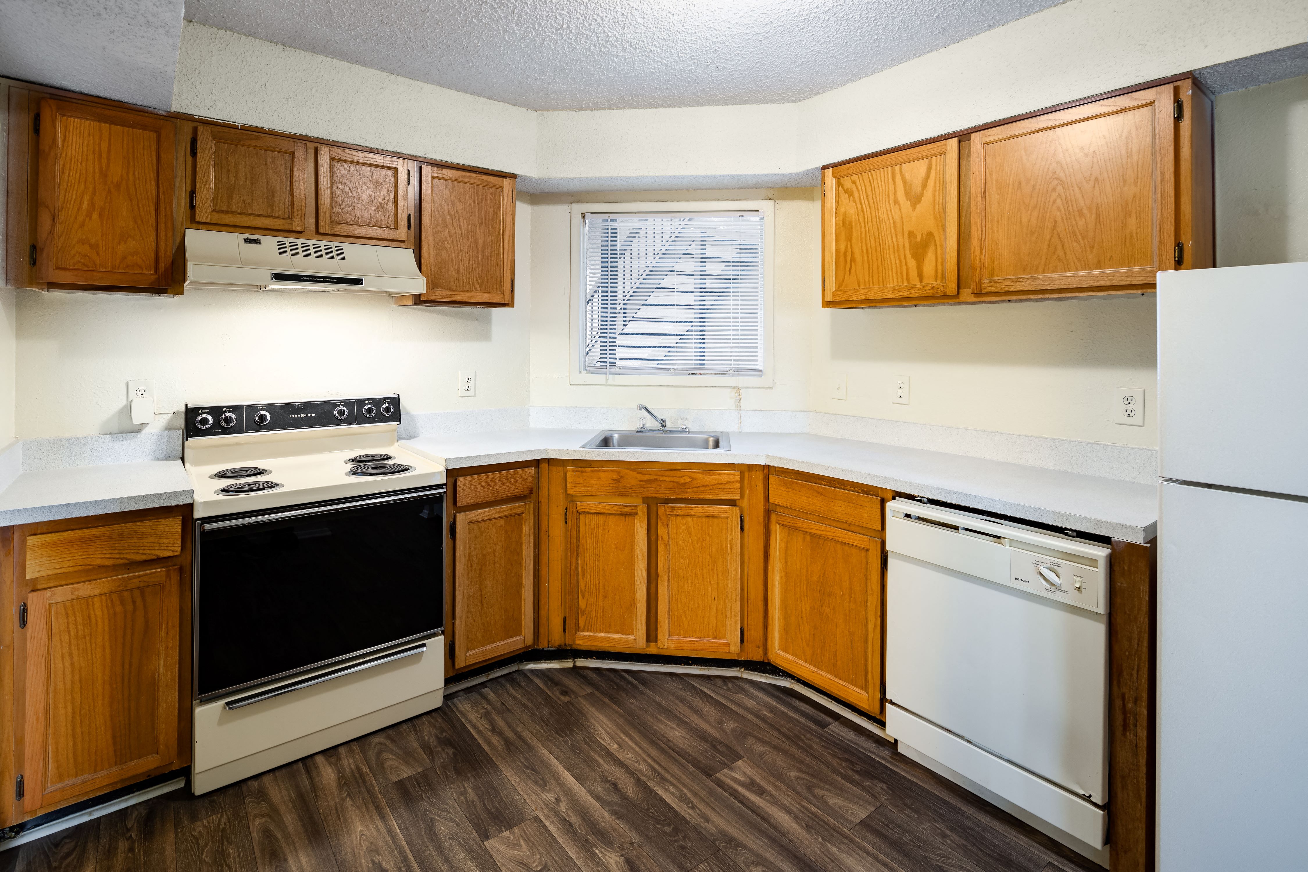 a kitchen with white appliances and wooden cabinets