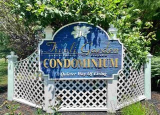 a sign for condominiums in front of a white fence