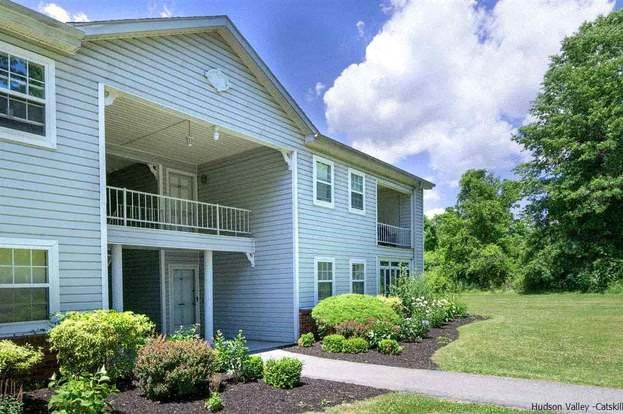 a blue house with a front porch and a lawn