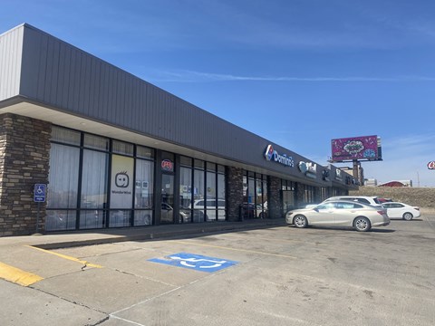 A car is parked in a handicapped parking spot outside a Dairy Queen.
