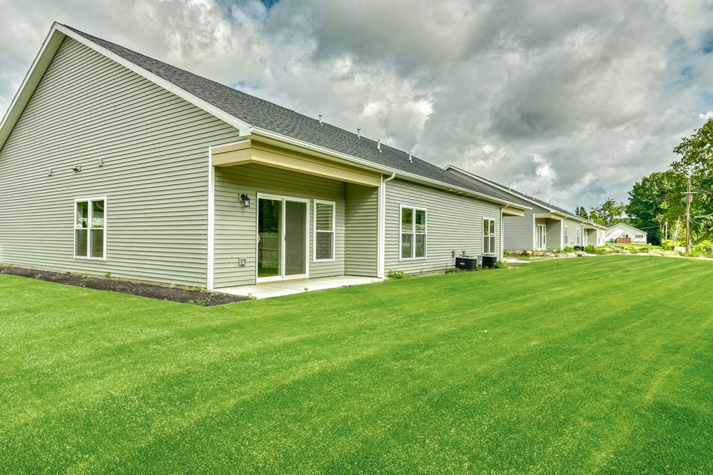 a white house with a green lawn in front of it