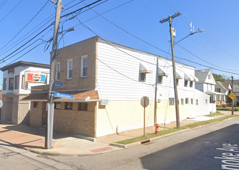 A white building with a red fire hydrant in front of it.