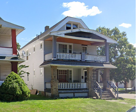 A two-story house with a balcony and a front porch.