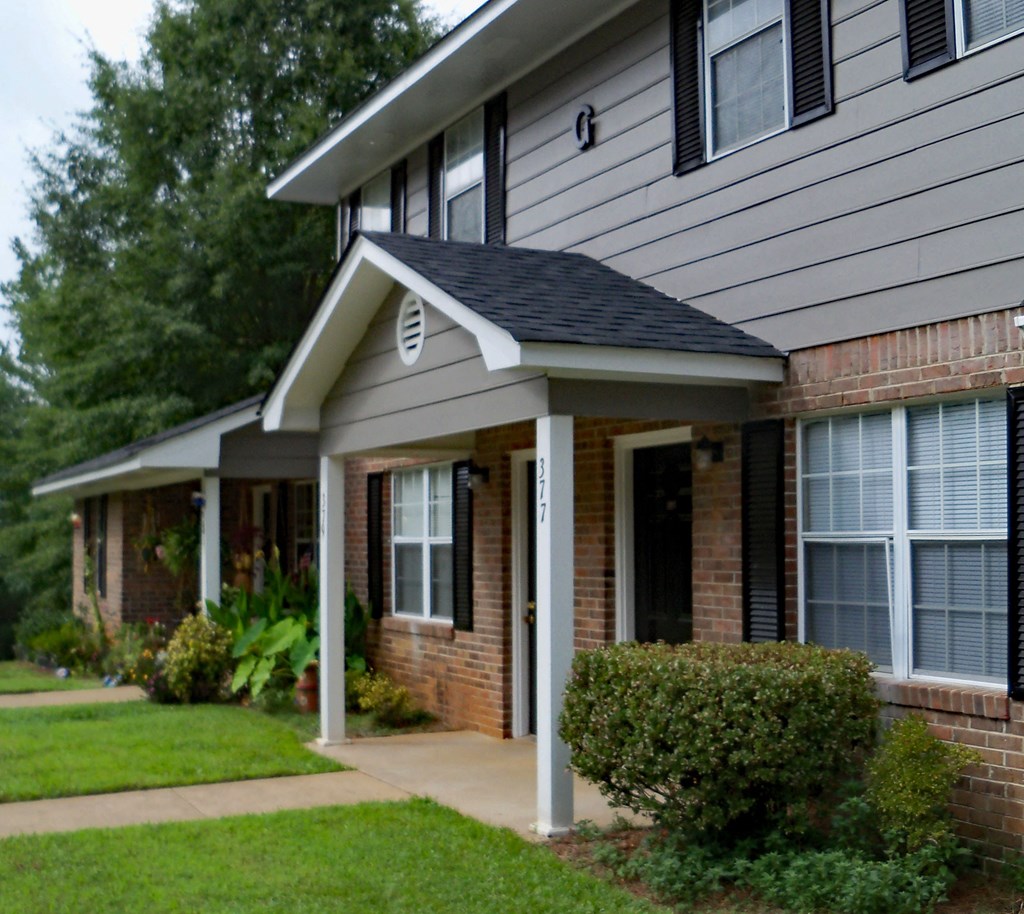 a house with a porch and a sidewalk in front of it