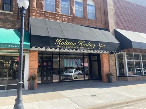 the front of a restaurant with a black awning on a building