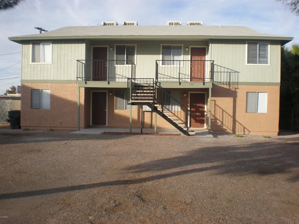 the front of a house with a balcony and a driveway