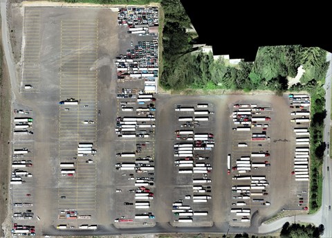 an aerial view of a parking lot filled with cars