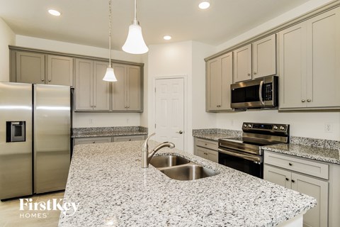 A kitchen with granite countertops and stainless steel appliances.