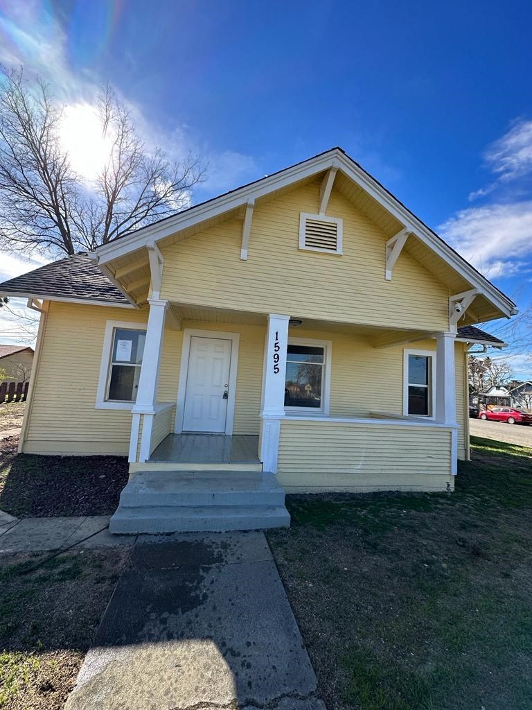 the front of a yellow house with a white door