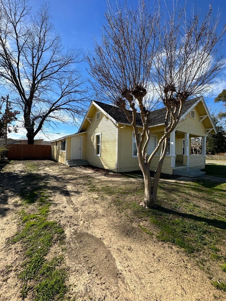 a yellow house with a tree in front of it