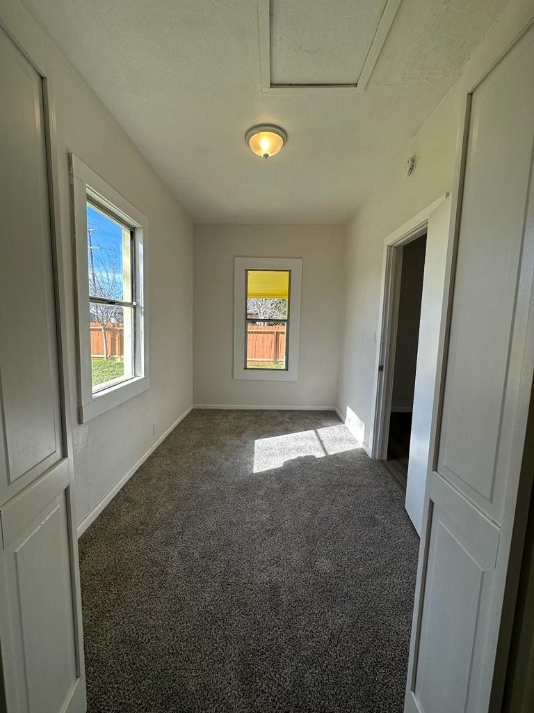 a empty room with a carpeted floor and a window