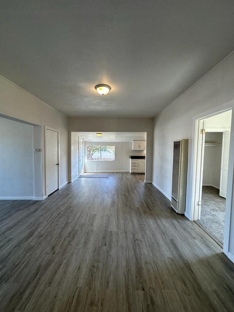 an empty living room with a hard wood floor