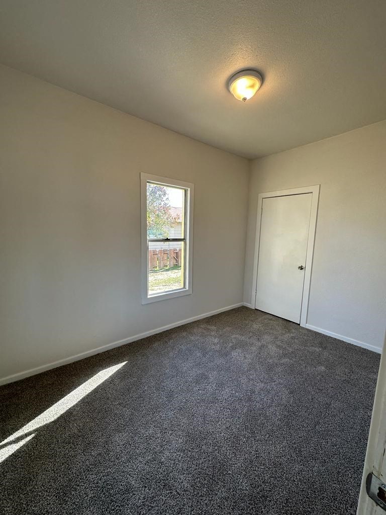 an empty room with a door and a window