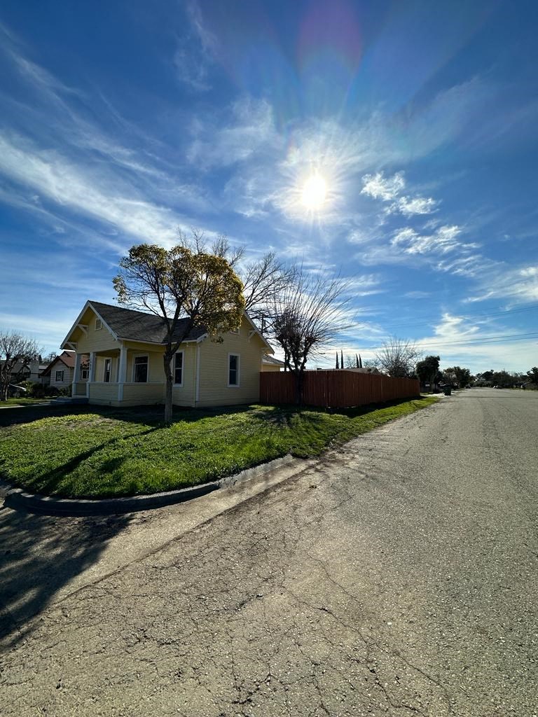 a yellow house sitting on the side of a road