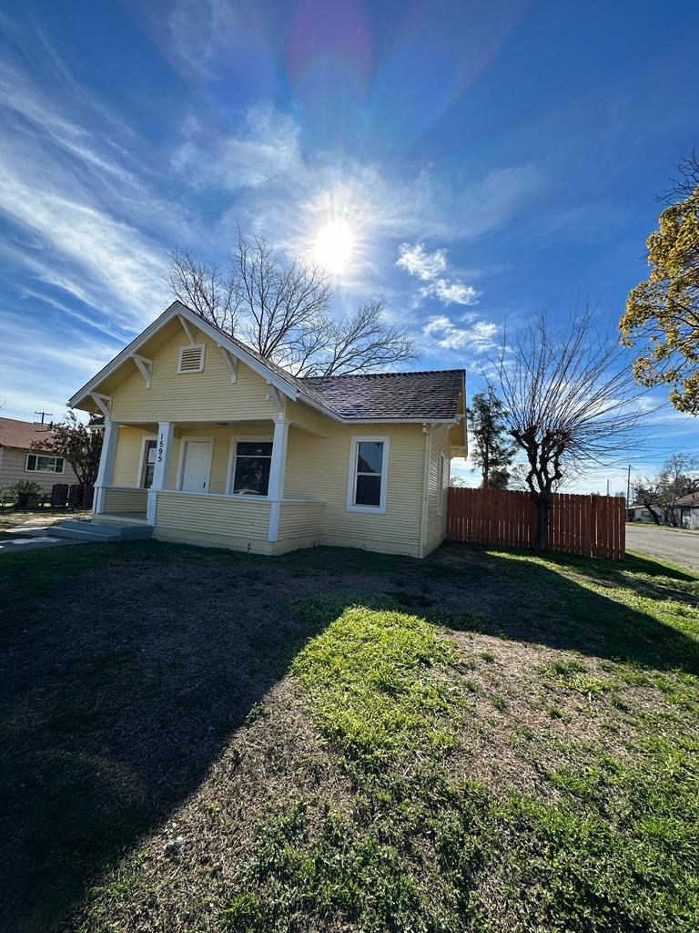a small yellow house with the sun in the sky