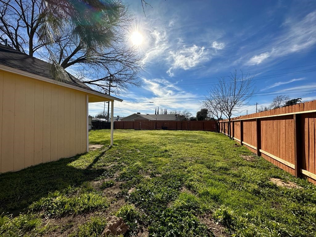 a backyard with a wooden fence and a grass yard