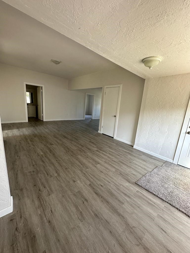 an empty living room with a wood floor