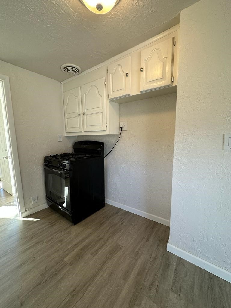 a kitchen with an oven and cabinets in a room