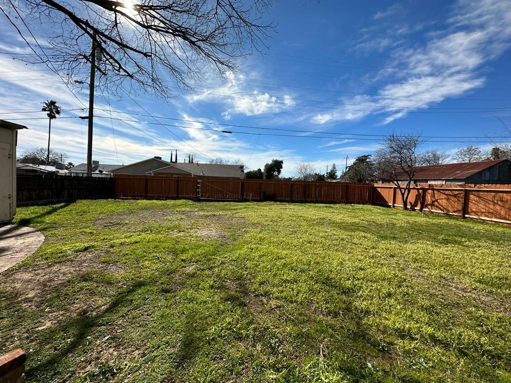 a backyard with a wooden fence and a grass yard