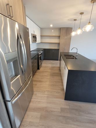 a large kitchen with stainless steel appliances and black counter tops