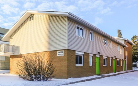 a yellow and brown house with snow on the ground